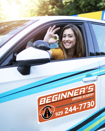 Car driving student showing okay gesture sign and sitting at vehicle driver position.