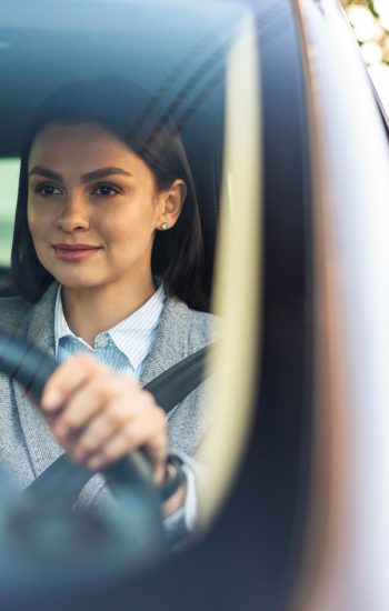 smiley-businesswoman-driving-her-car